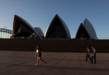 Australia tips into record budget deficit as government cuts tax, boosts jobs support